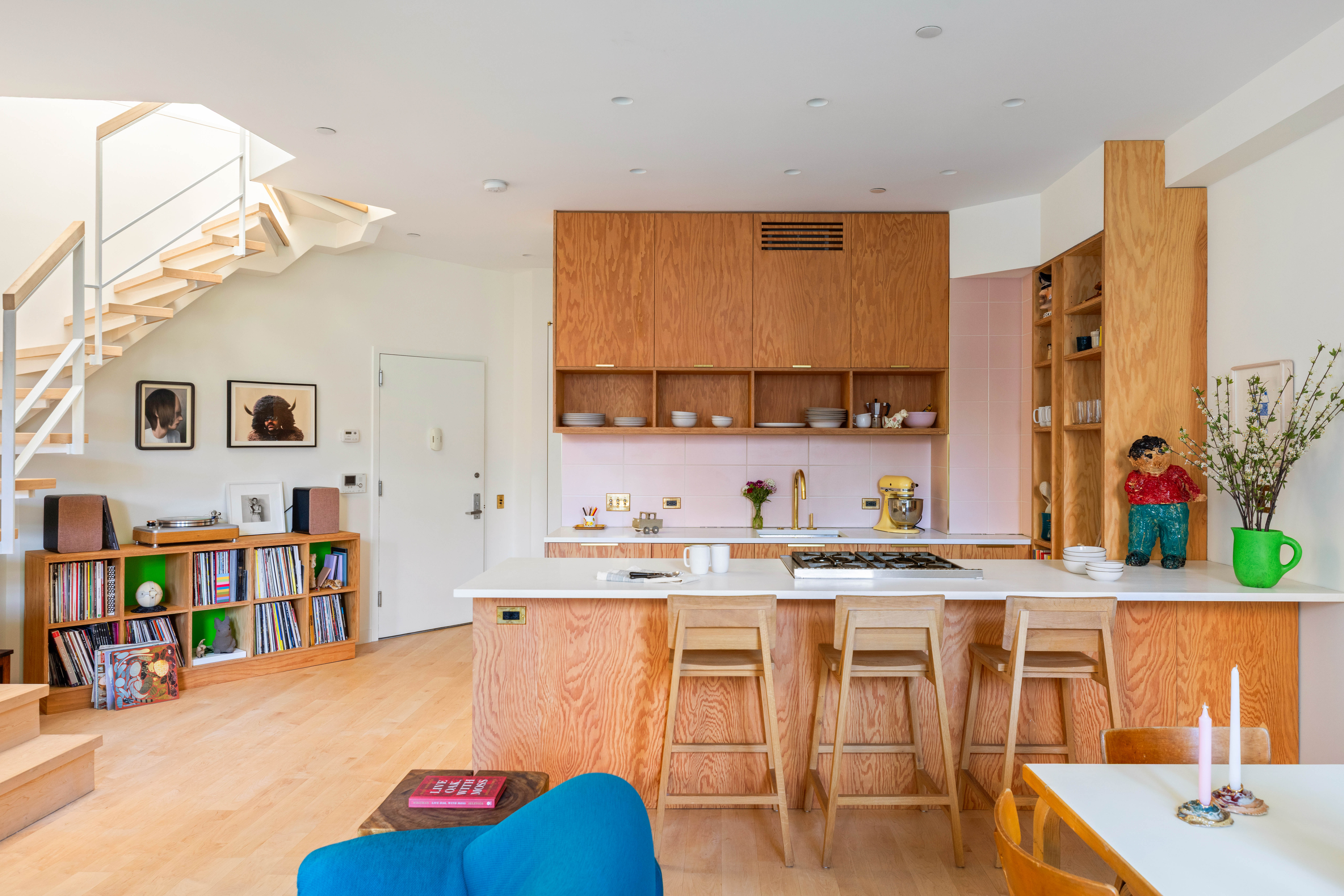 130 Jane Street, Unit 5/6F Manhattan, NY 10014 - Photo 3 of 23 a living room with stainless steel appliances lots of white furniture and a book shelf