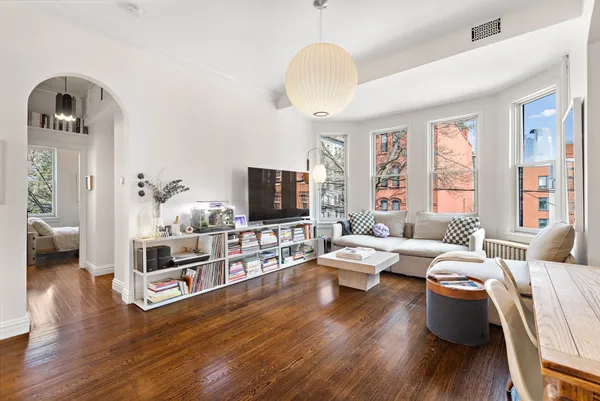 a living room with furniture flat screen tv and wooden floor