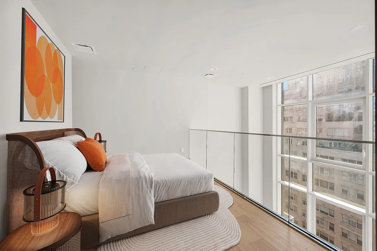 1059 3rd Avenue, Unit 10C Manhattan, NY 10065 - Photo 4 of 7 a bedroom with a bed and wooden floor