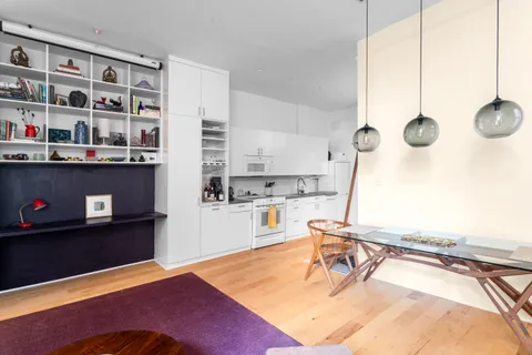 a living room with furniture a flat screen tv and a stove