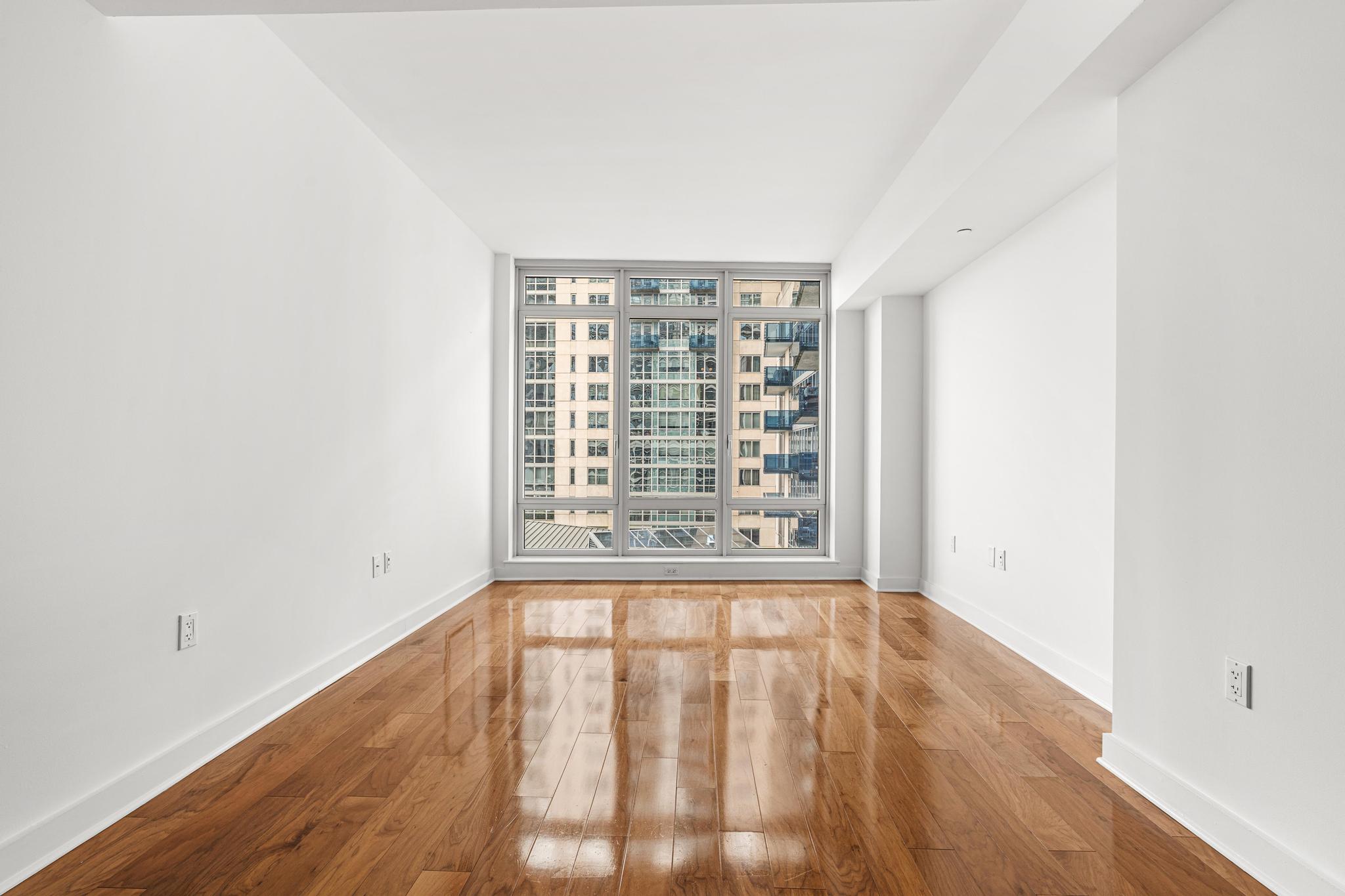 2 Northside Piers, Unit 5U Brooklyn, NY 11249 - Photo 4 of 12 a view of an empty room with wooden floor and a window