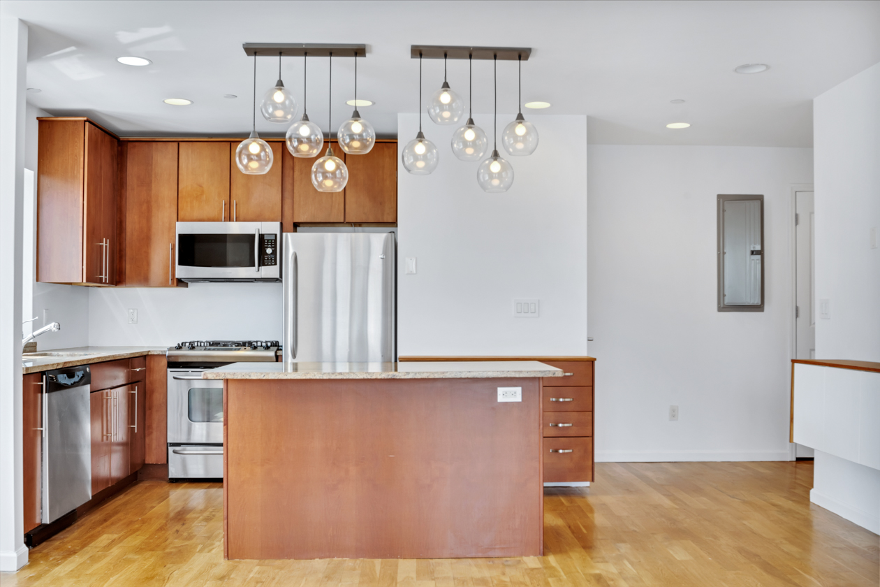 416 East 117th Street, Unit PH6 Manhattan, NY 10035 - Photo 6 of 20 a kitchen with stainless steel appliances granite countertop a stove a sink and a refrigerator