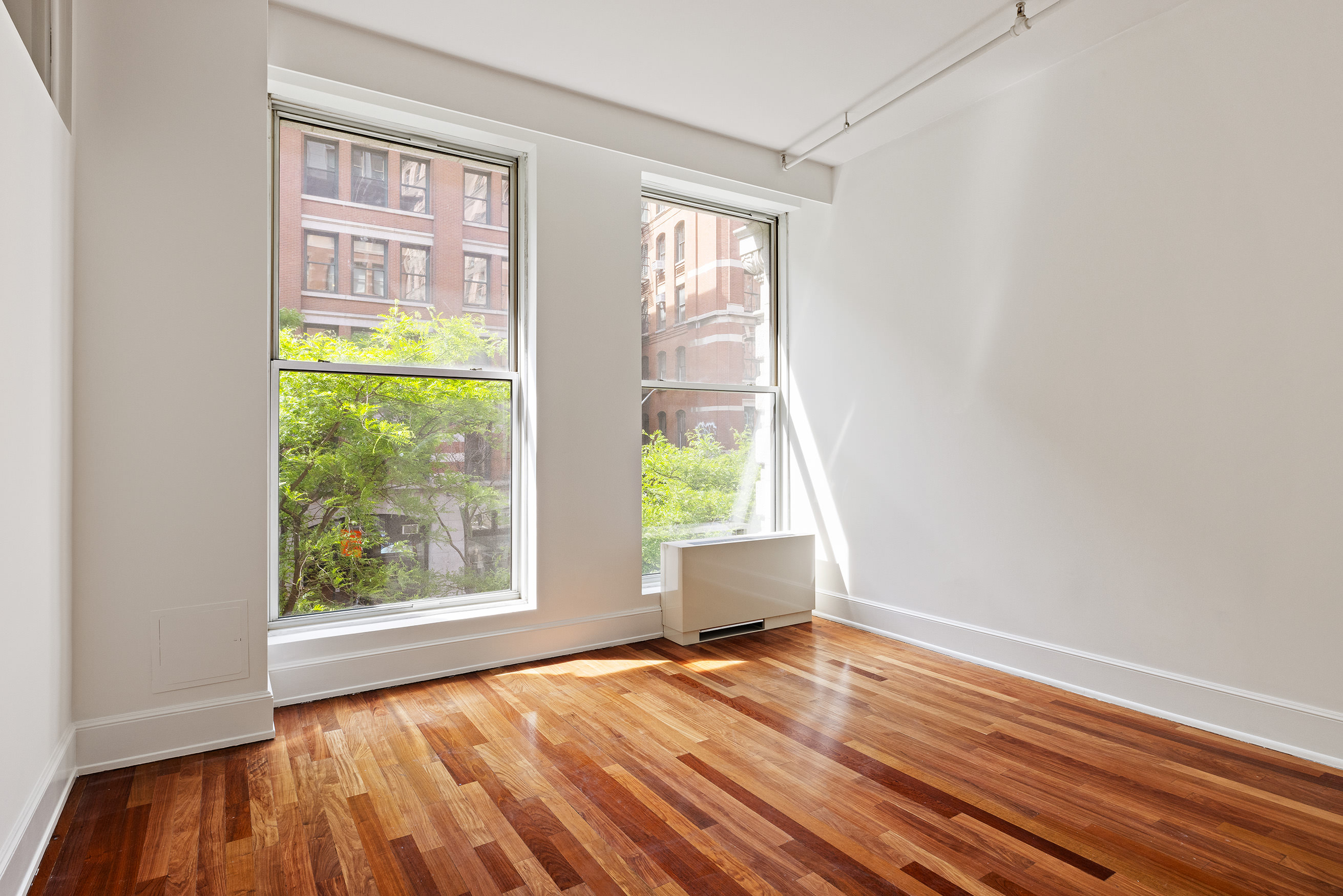 285 Lafayette Street, Unit 2B Manhattan, NY 10012 - Photo 10 of 19 a view of an empty room with wooden floor and a window