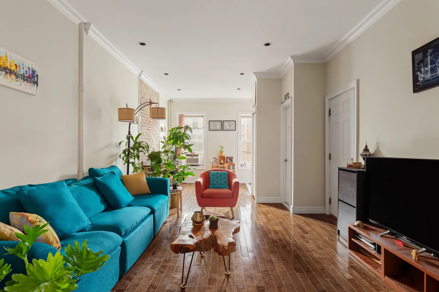 a living room with furniture a flat screen tv and a dining table