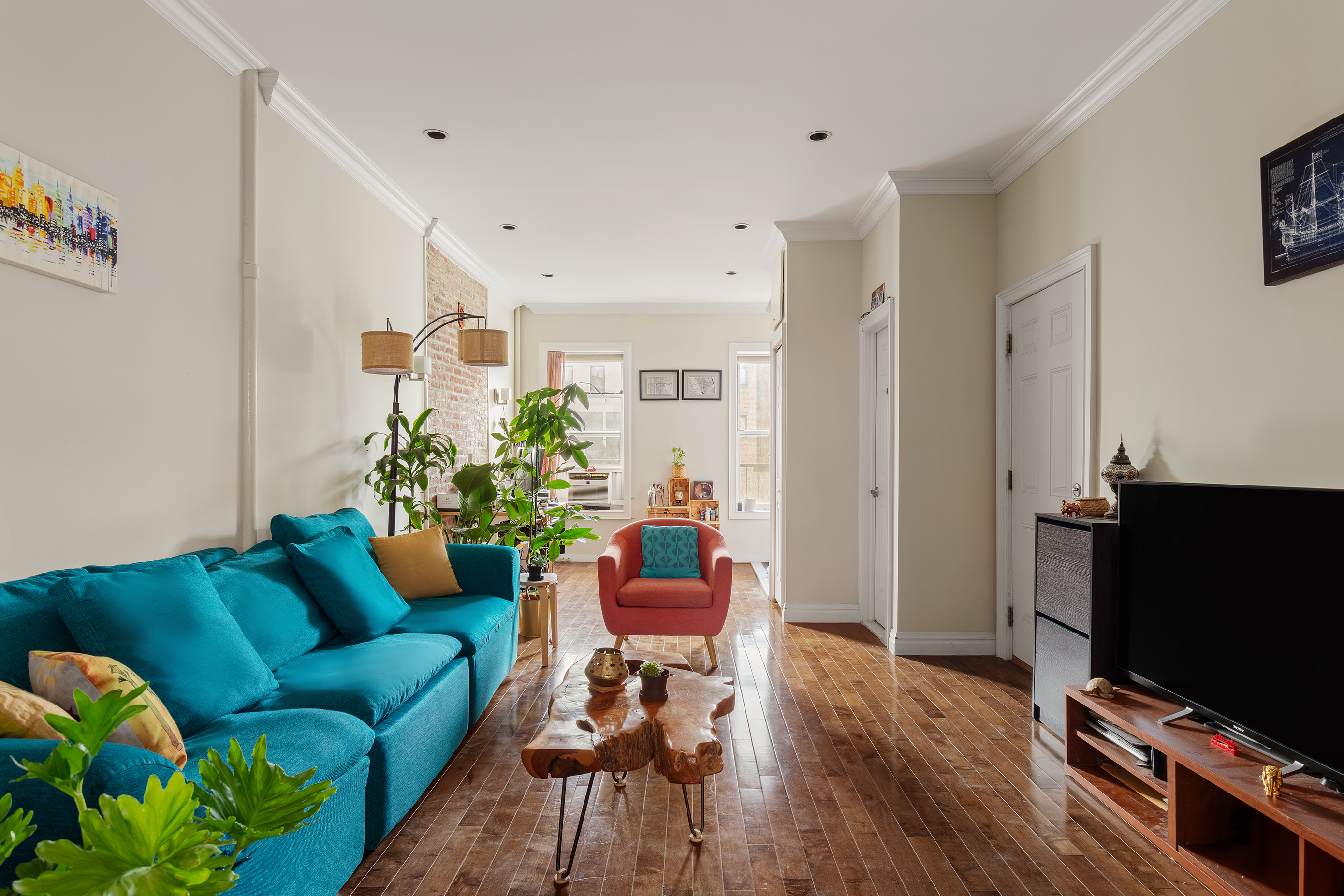 a living room with furniture a flat screen tv and a dining table