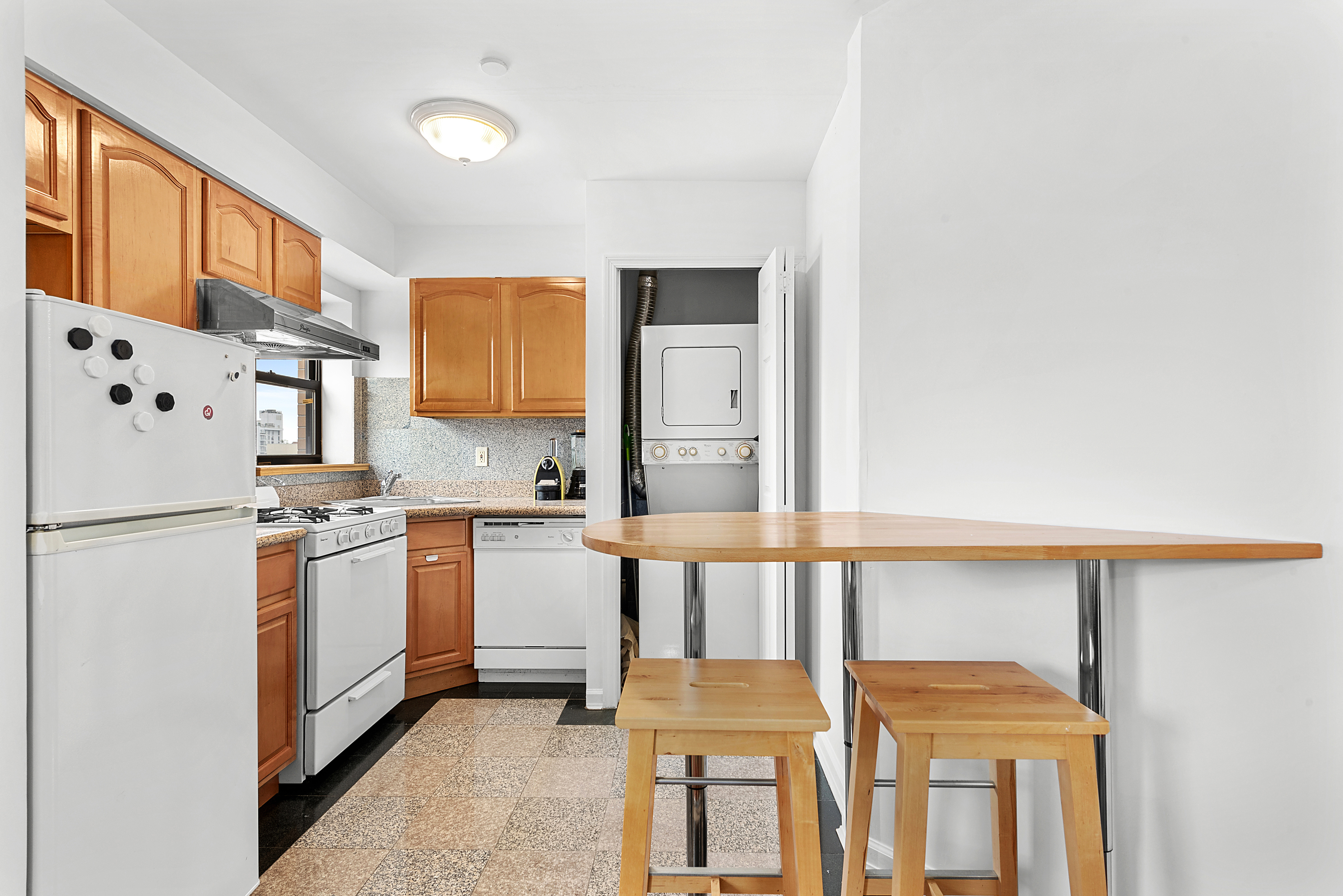62 Rivington Street, Unit 9A Manhattan, NY 10002 - Photo 3 of 6 a kitchen with stainless steel appliances granite countertop a refrigerator and a stove top oven