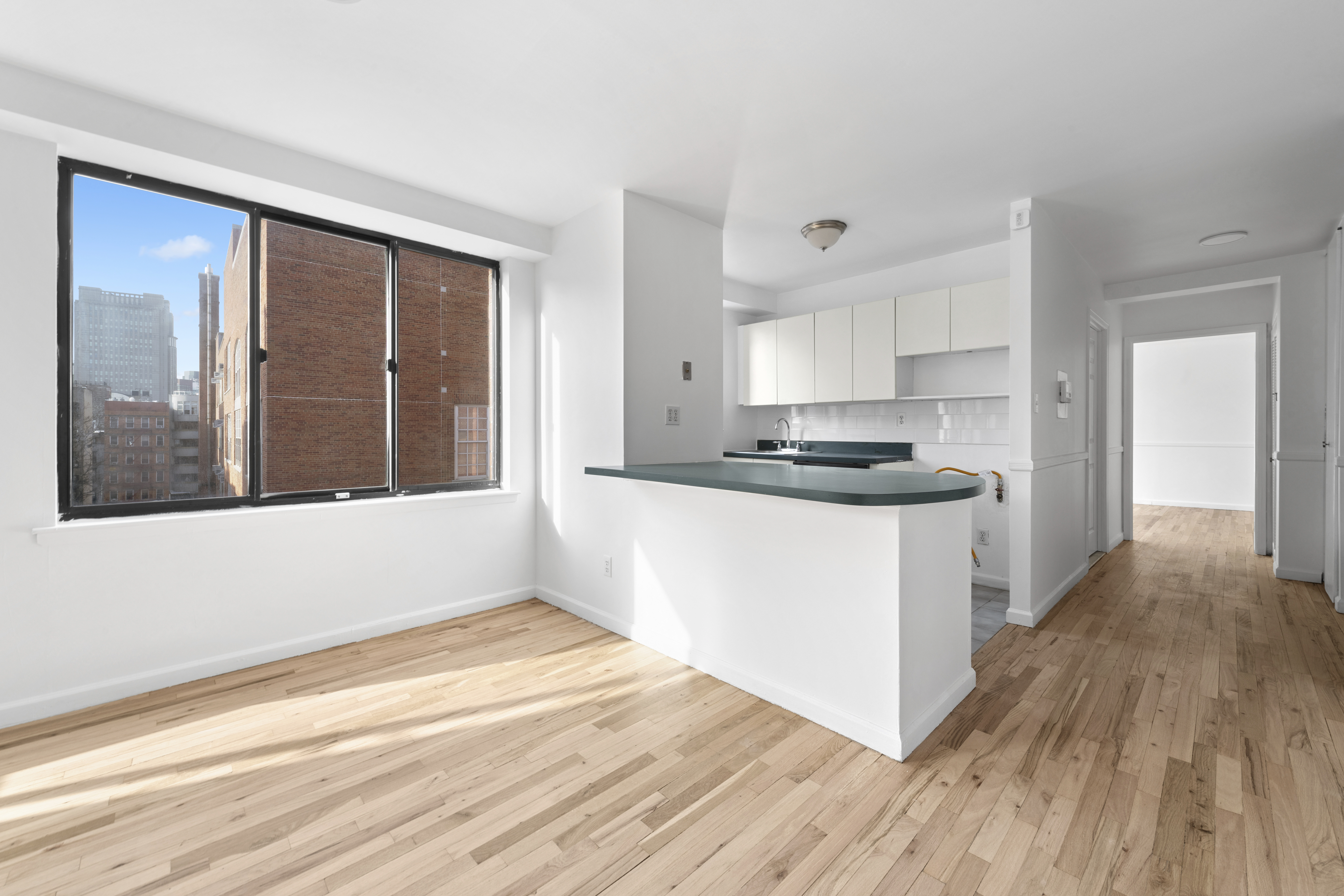 179 Grand Street, Unit 6G Manhattan, NY 10013 - Photo 5 of 8 a kitchen with granite countertop stainless steel appliances sink and cabinets