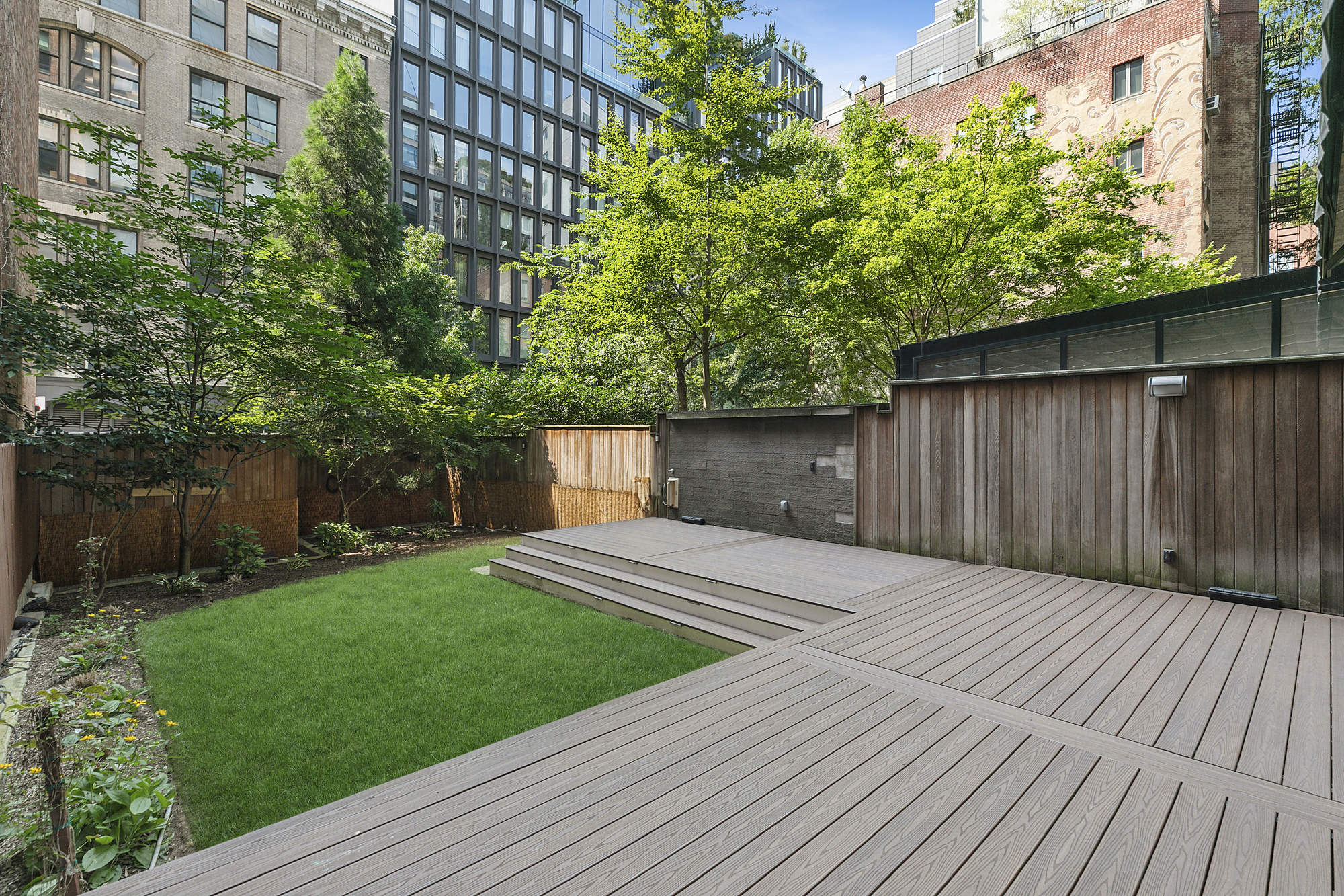 255 Hudson Street, Unit TH1 Manhattan, NY 10013 - Photo 2 of 10 a view of a backyard with plants and wooden fence