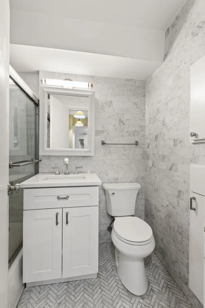 a bathroom with a toilet a sink and mirror