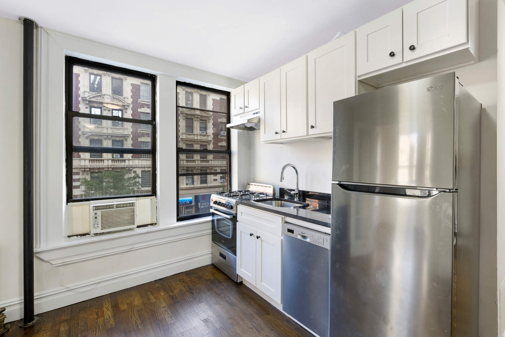 24 East 97th Street, Unit 10 Manhattan, NY 10128 - Photo 2 of 7 a kitchen with stainless steel appliances a refrigerator and a stove