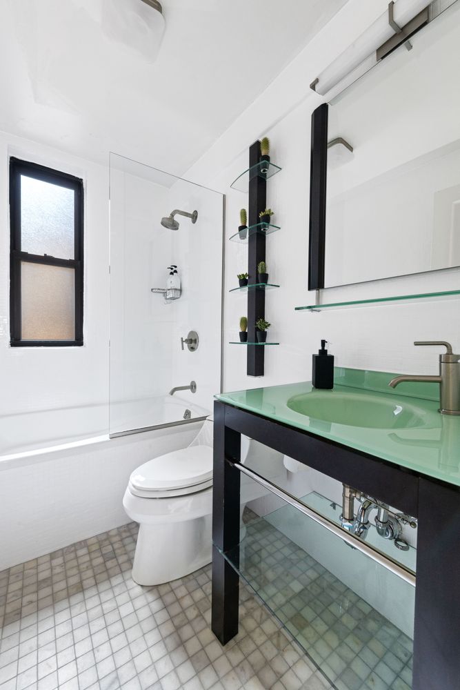 333 East 53rd Street, Unit 3KL Manhattan, NY 10022 - Photo 8 of 10 a bathroom with a toilet a sink and mirror