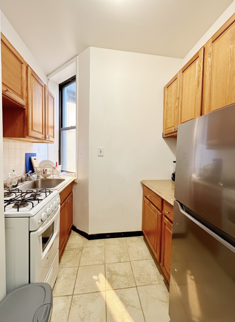 169 Allen Street, Unit 5C Manhattan, NY 10002 - Photo 2 of 11 a kitchen with a sink stove and cabinets
