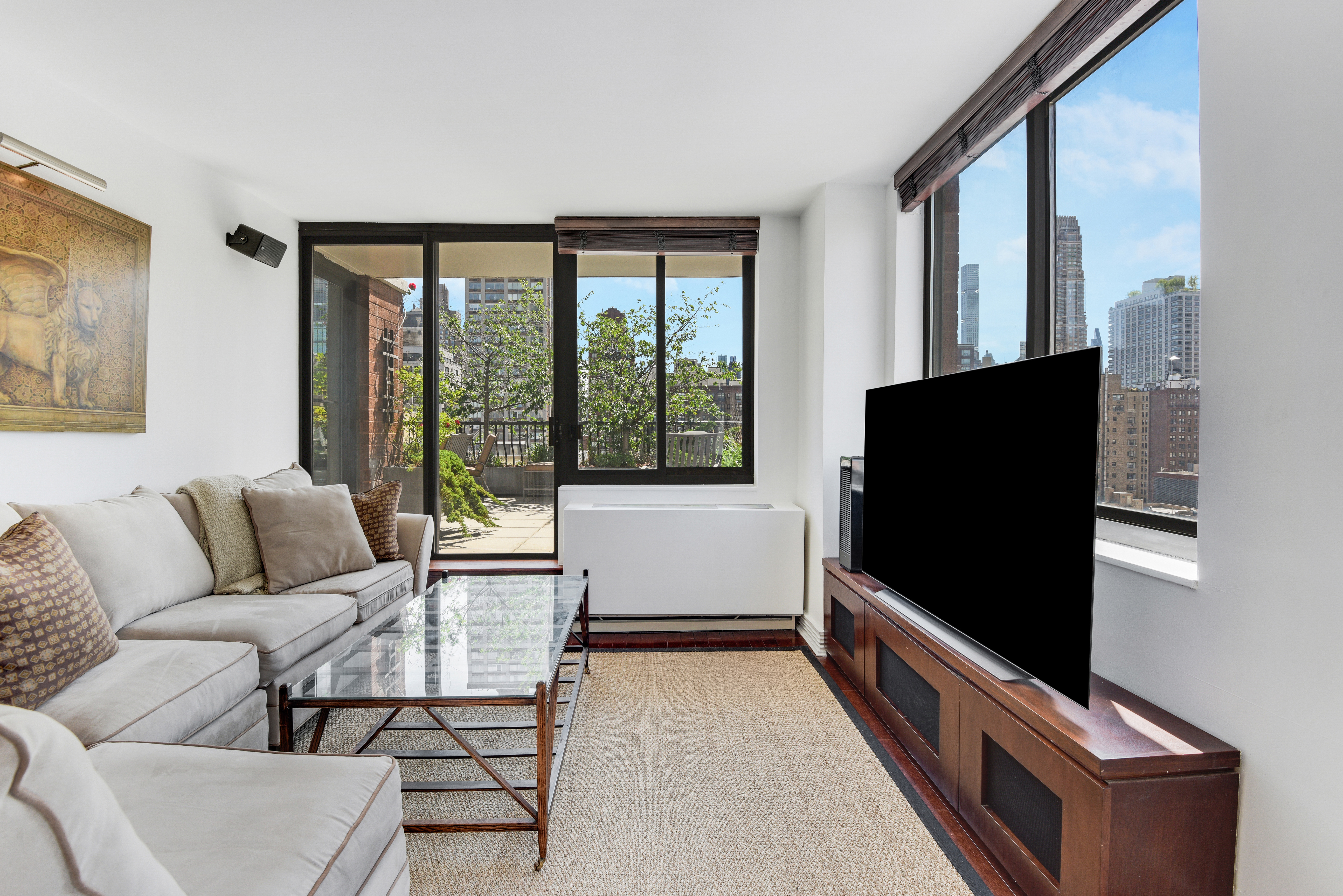 343 East 74th Street, Unit 15D Manhattan, NY 10021 - Photo 4 of 14 a living room with furniture and a flat screen tv