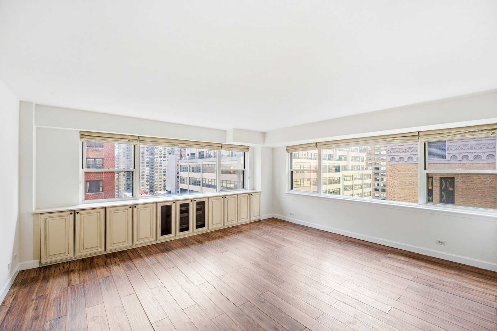 139 East 33rd Street, Unit 12DE Manhattan, NY 10016 - Photo 2 of 27 an empty room with wooden floor and windows