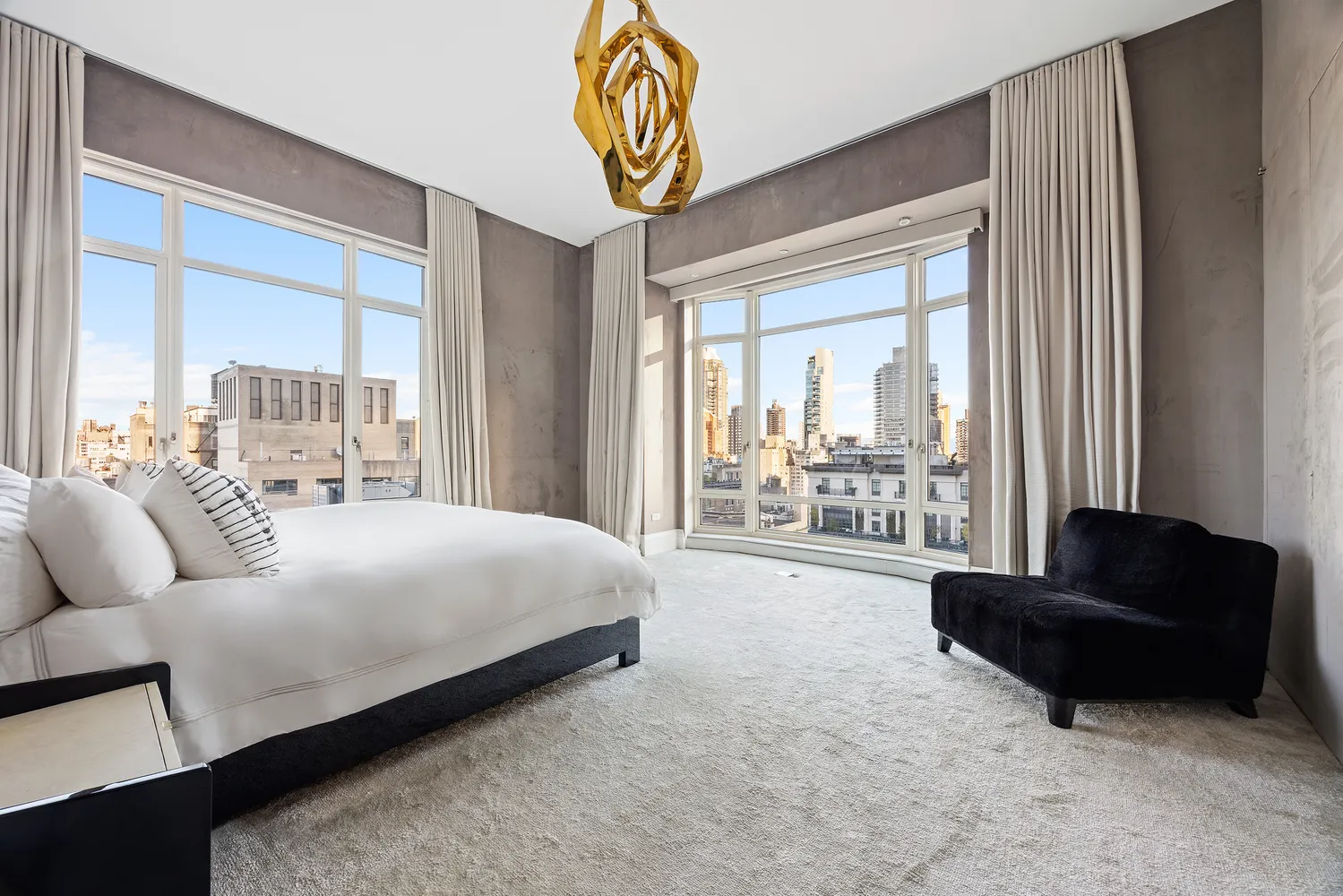 a spacious bedroom with a bed and a couch next to a window
