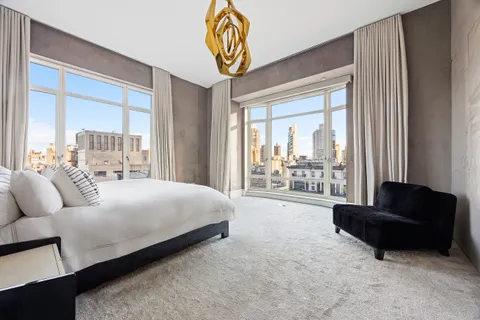 a spacious bedroom with a bed and a couch next to a window