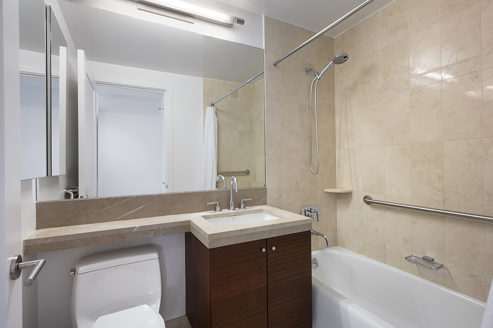 30 West Street, Unit 21AB Manhattan, NY 10004 - Photo 11 of 17 a bathroom with a sink vanity mirror and toilet