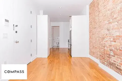 a view of a bedroom with wooden floor and bathroom
