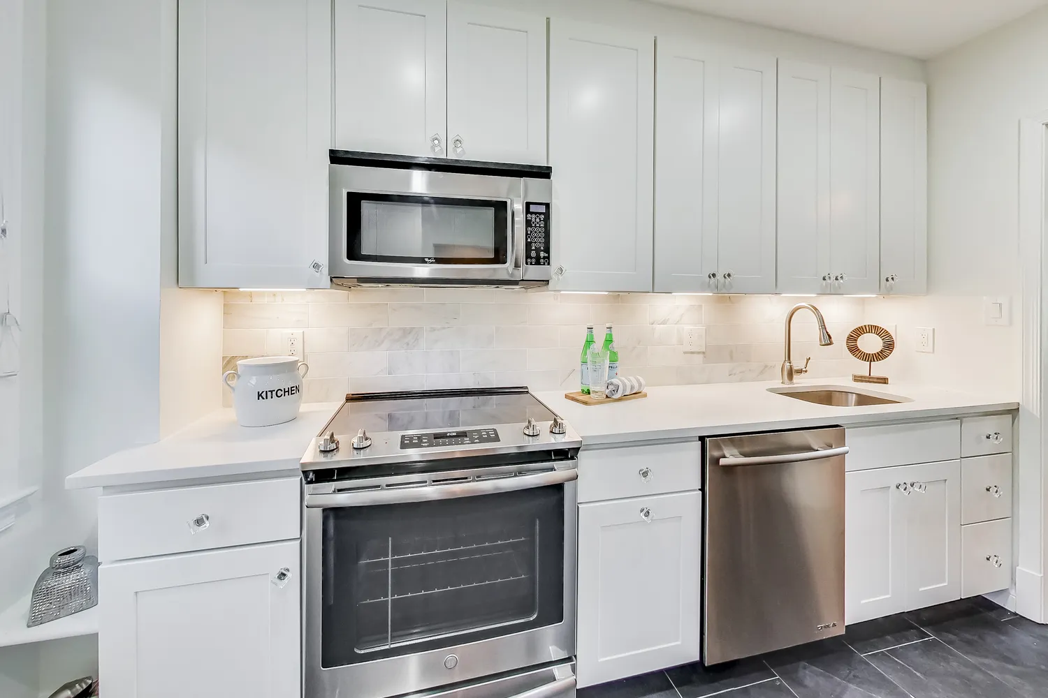 a kitchen with white cabinets and stainless steel appliances
