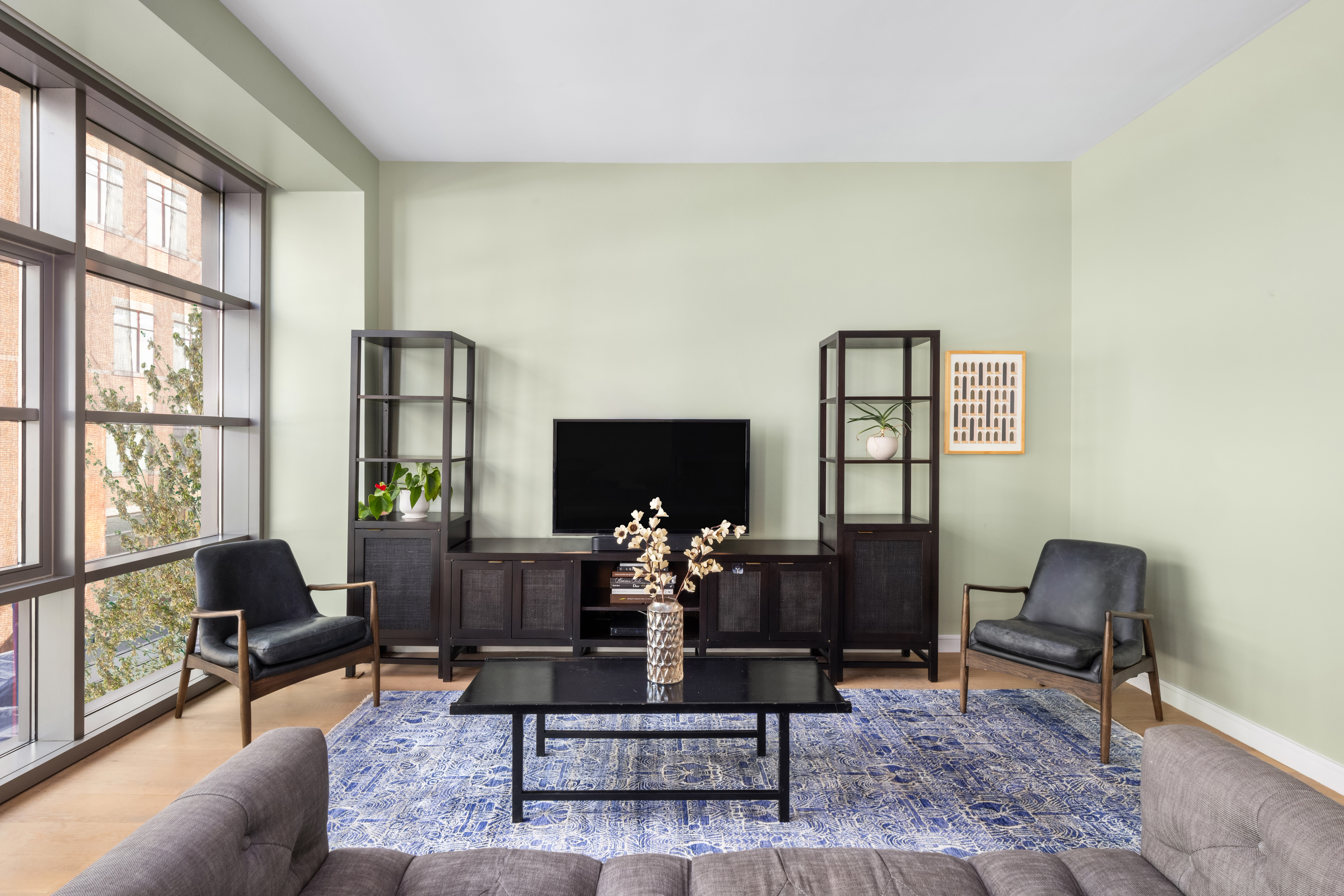 138 North 10th Street, Unit 302 Brooklyn, NY 11249 - Photo 3 of 15 a living room with couches coffee table and a flat screen tv with wooden floor