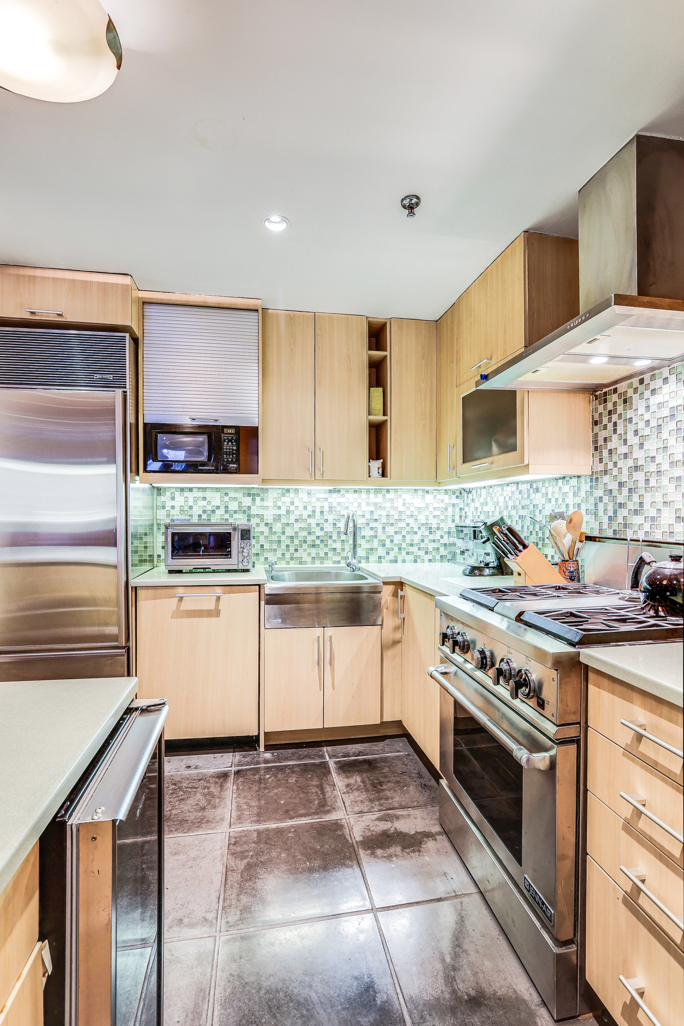 136-140 West 23rd Street, Unit 4C Manhattan, NY 10011 - Photo 5 of 12 a kitchen with stainless steel appliances granite countertop a stove a sink and a refrigerator