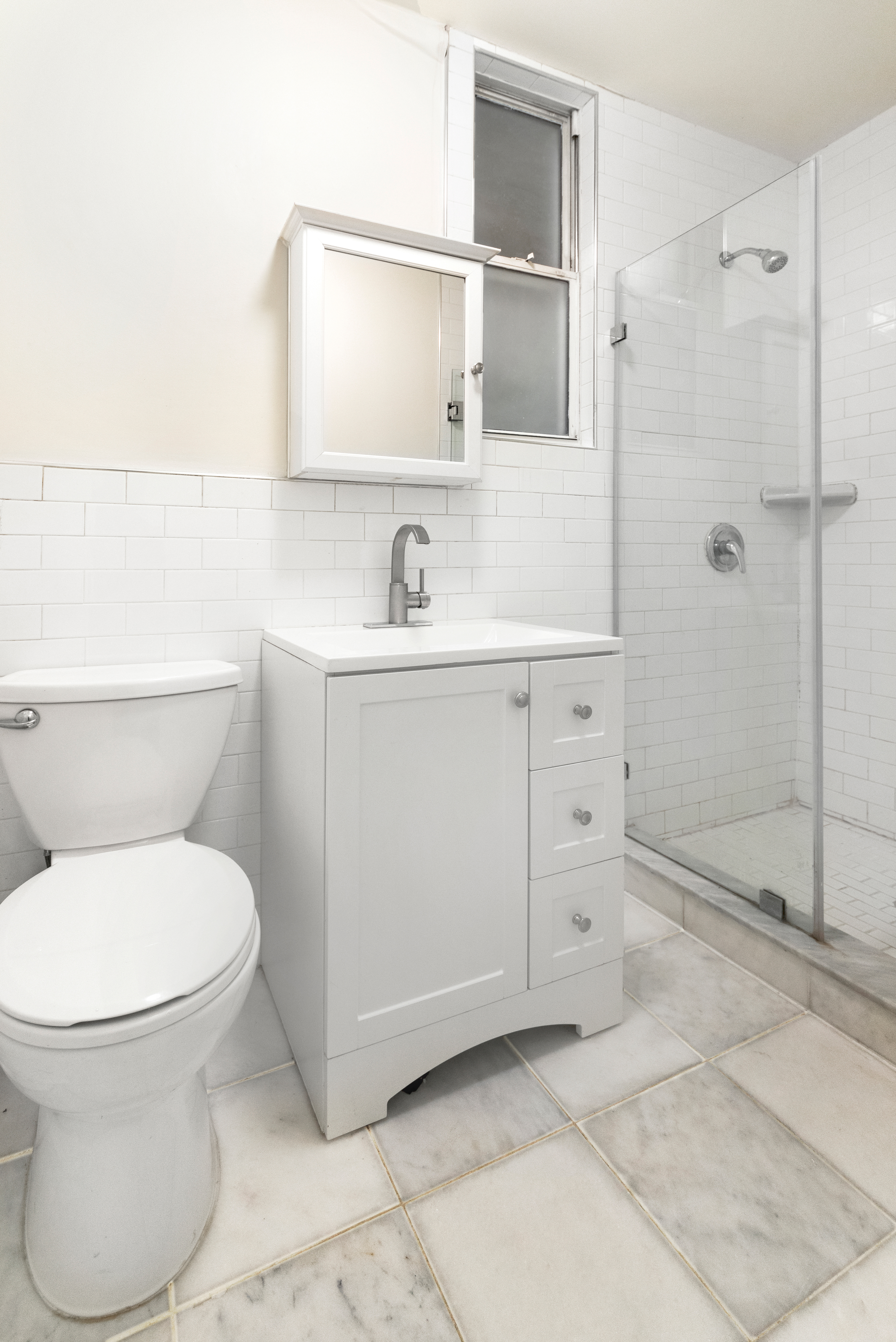 1605 York Avenue, Unit 1A Manhattan, NY 10028 - Photo 7 of 8 a bathroom with a toilet sink and shower