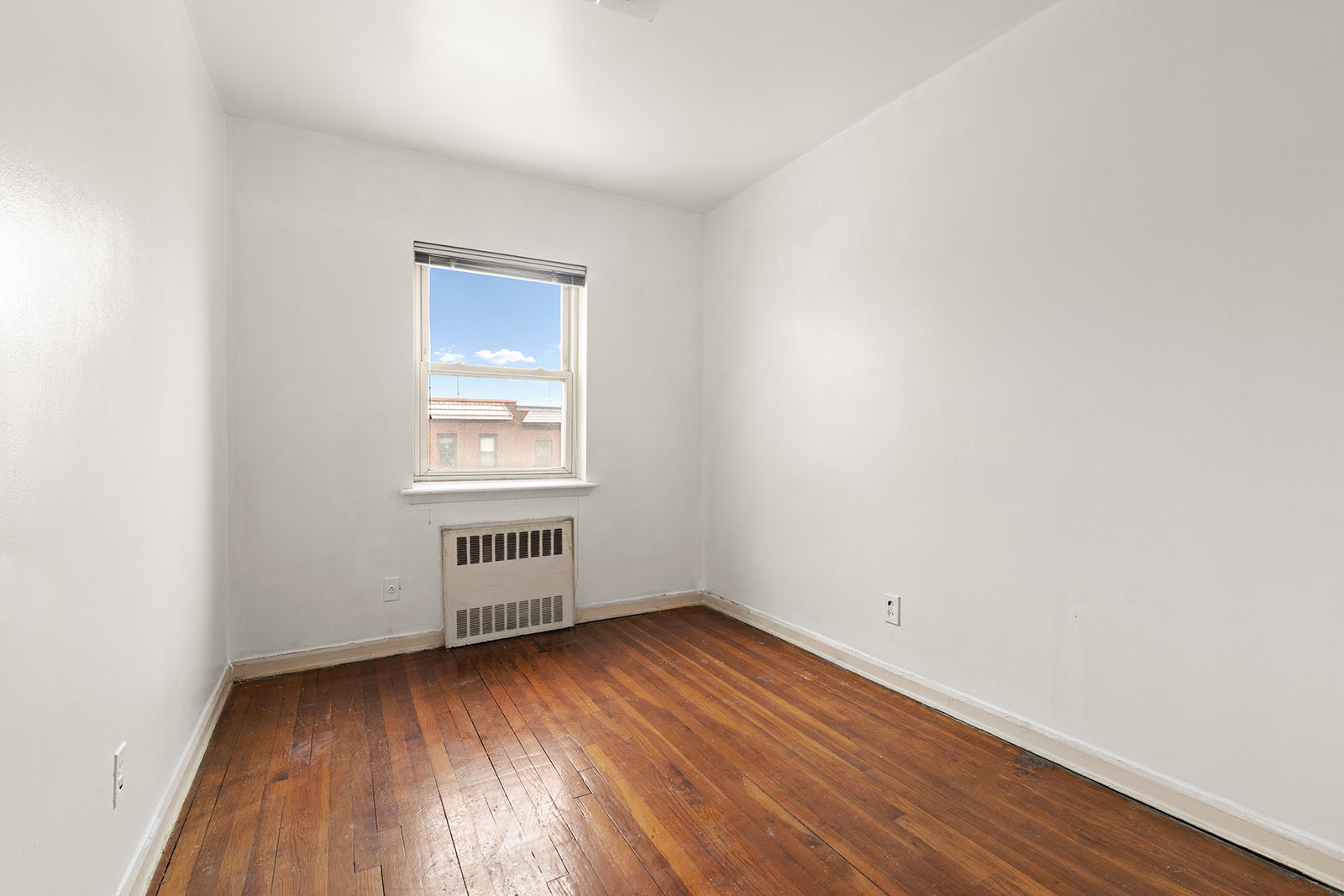 612 17th Street Brooklyn, NY 11218 - Photo 5 of 12 an empty room with wooden floor and windows