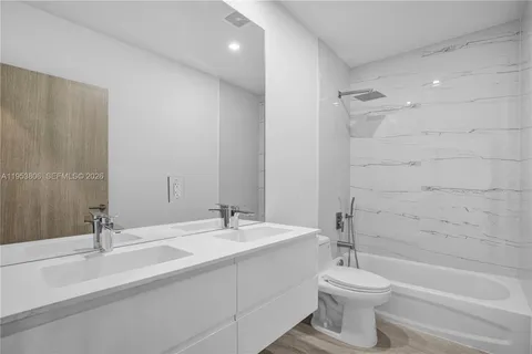 a bathroom with a double vanity sink toilet and shower