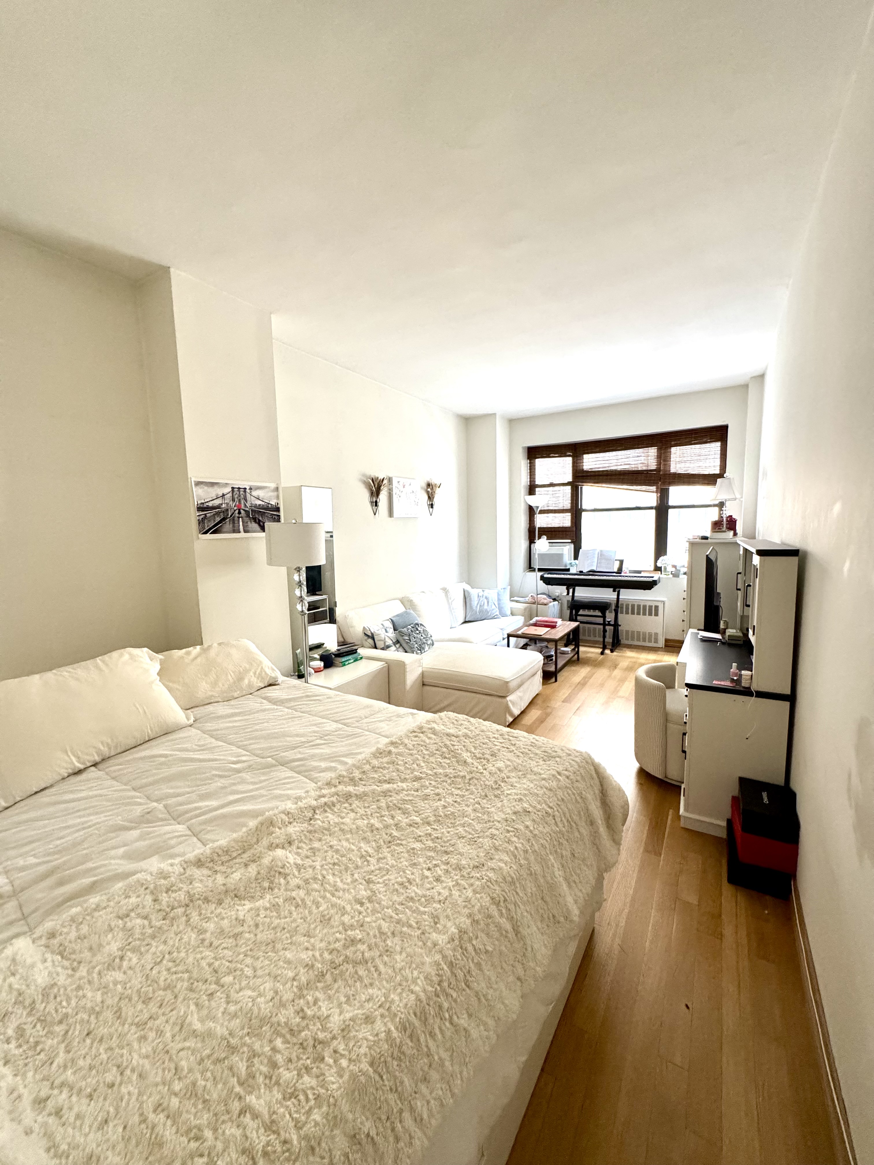 61 East 77th Street, Unit 7E Manhattan, NY 10075 - Photo 5 of 10 a bed room with a bed and a large window