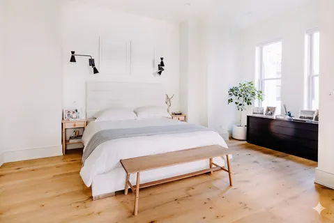 a bedroom with a bed and a potted plant