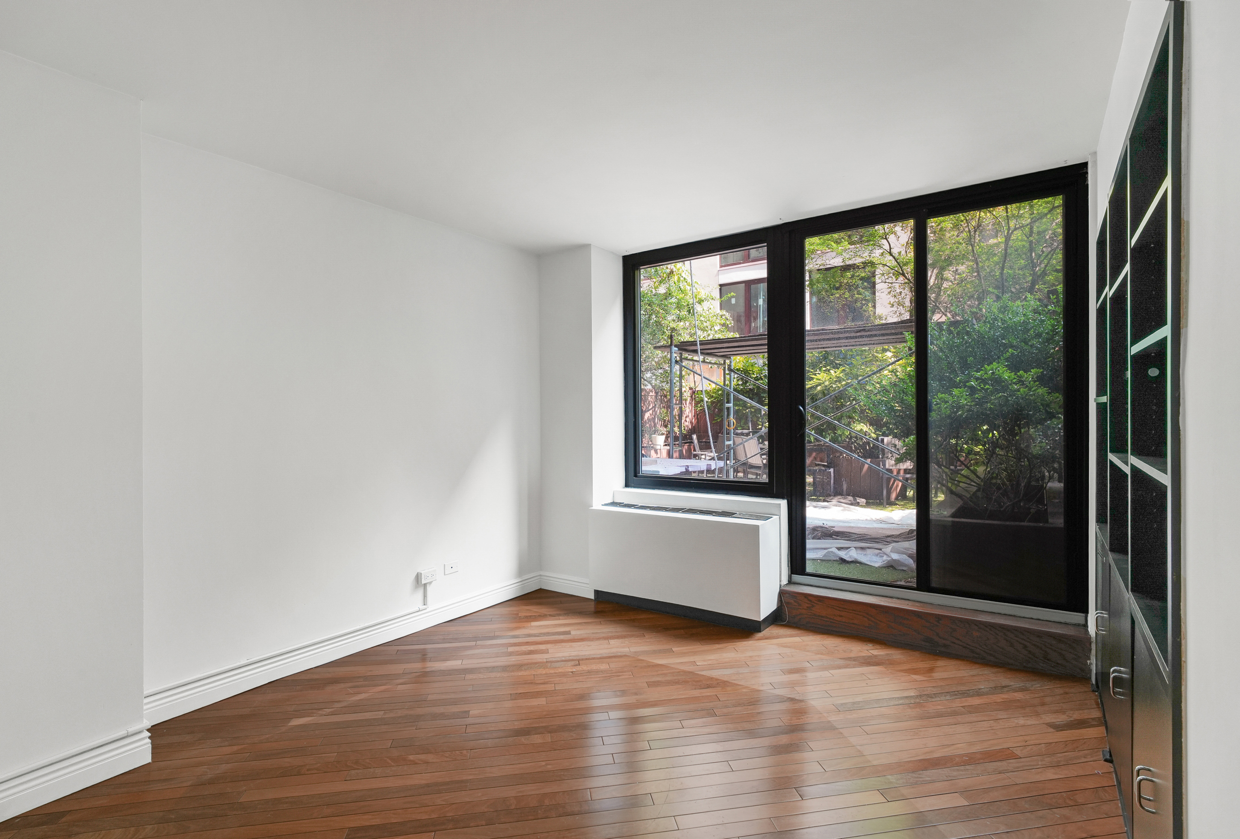 309 East 49th Street, Unit 2B3B Manhattan, NY 10017 - Photo 6 of 16 a view of empty room with wooden floor and floor to ceiling window