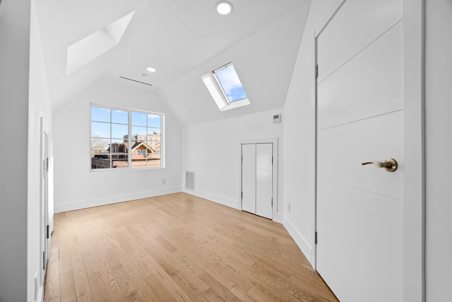 a view of a kitchen with wooden floor and a window