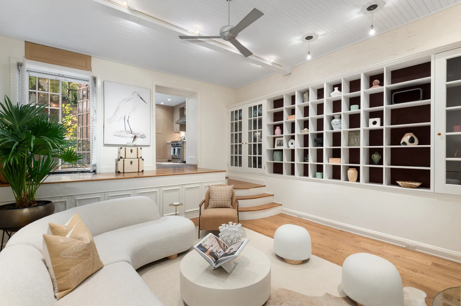 a living room with furniture potted plant and a large window