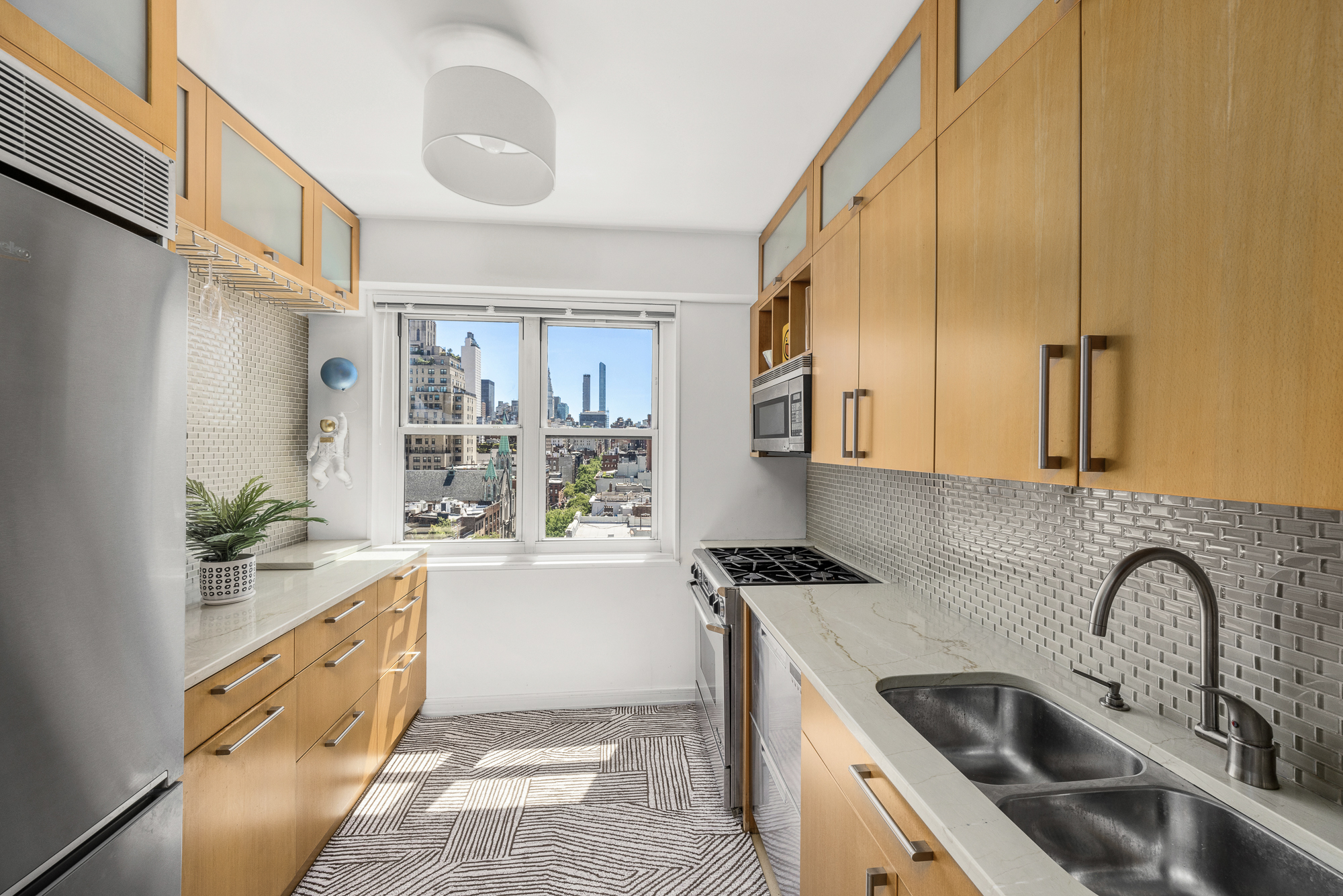 360 West 22nd Street, Unit 12L Manhattan, NY 10011 - Photo 7 of 21 a kitchen with granite countertop a sink and a stove top oven