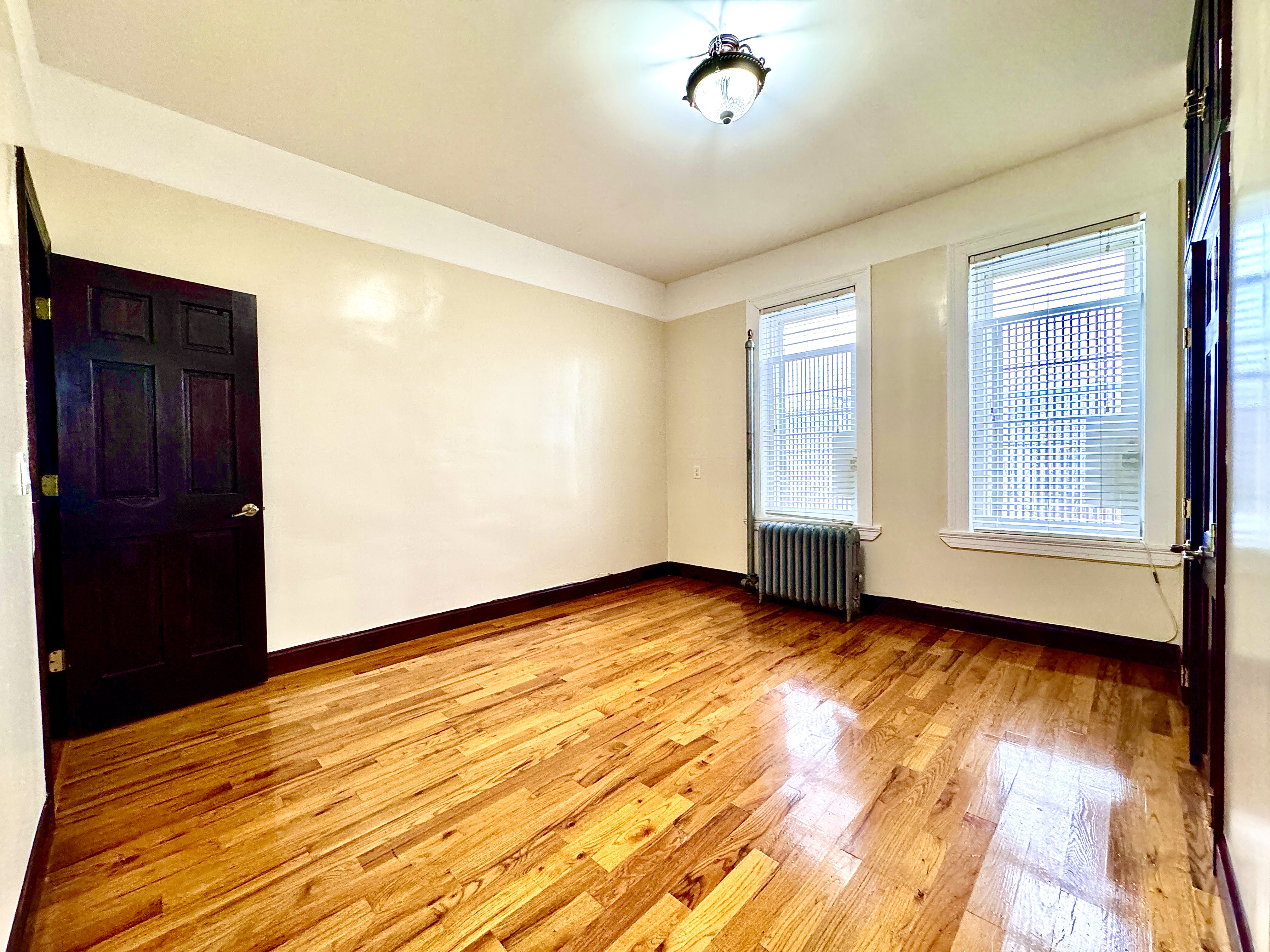 497 Park Place, Unit 4 Brooklyn, NY 11238 - Photo 3 of 14 wooden floor in an empty room with a window