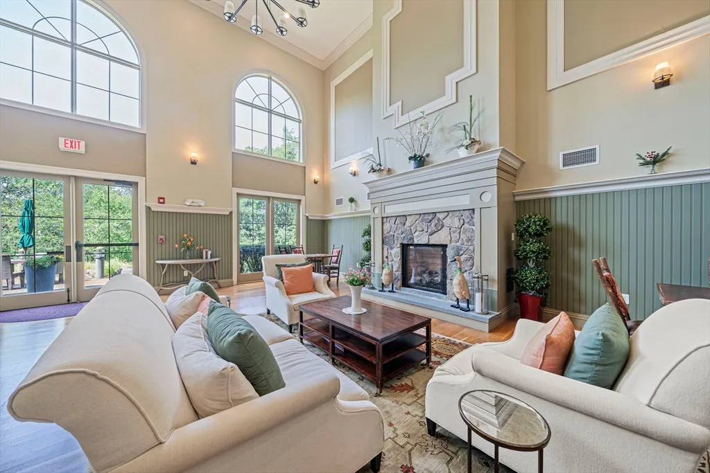 a living room with furniture fireplace and a large window
