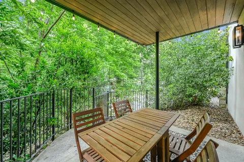 a view of a patio with table and chairs with wooden floor and fence