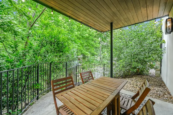 a view of a patio with table and chairs with wooden floor and fence