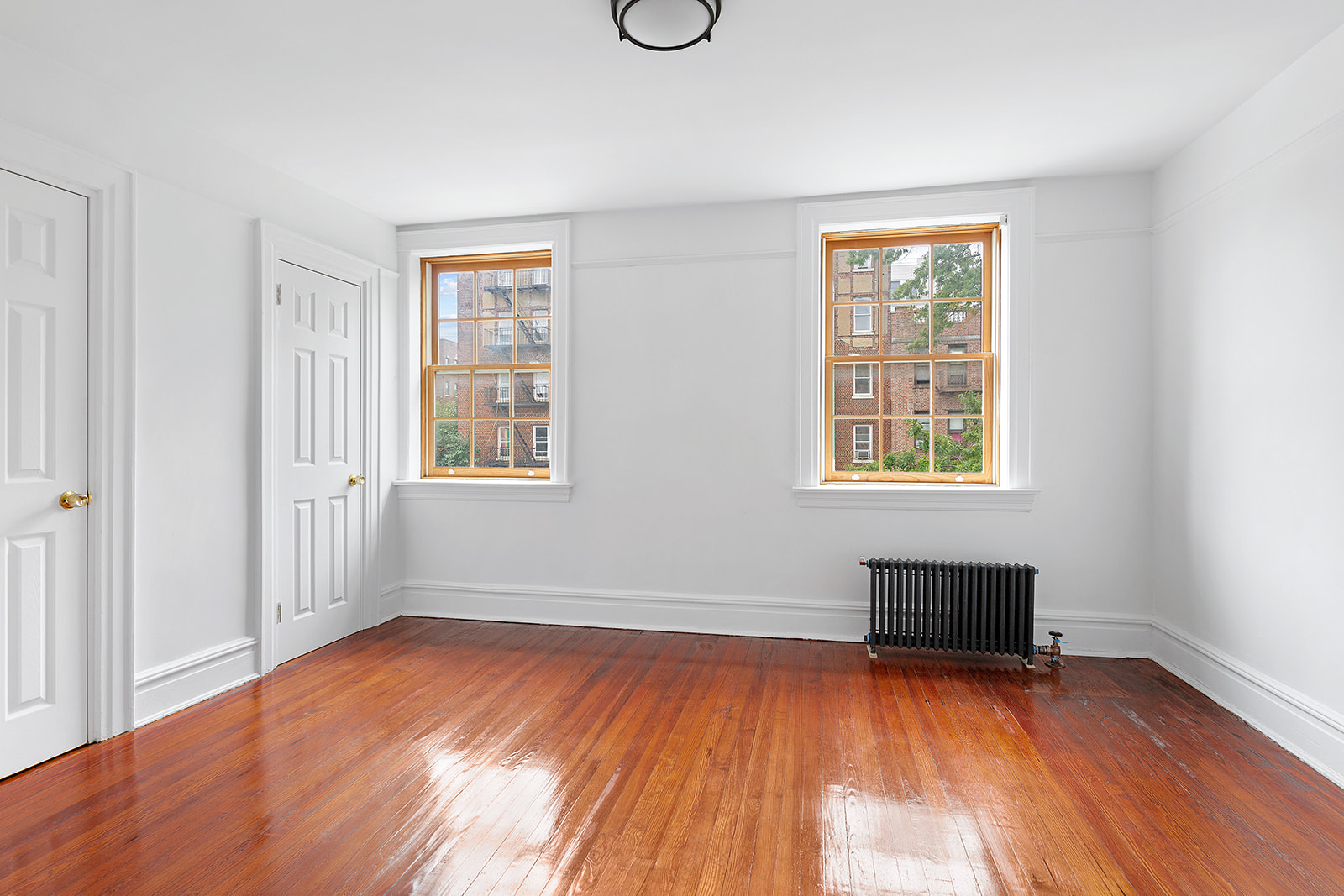 165 Fenimore Street Brooklyn, NY 11225 - Photo 8 of 13 an empty room with wooden floor and windows