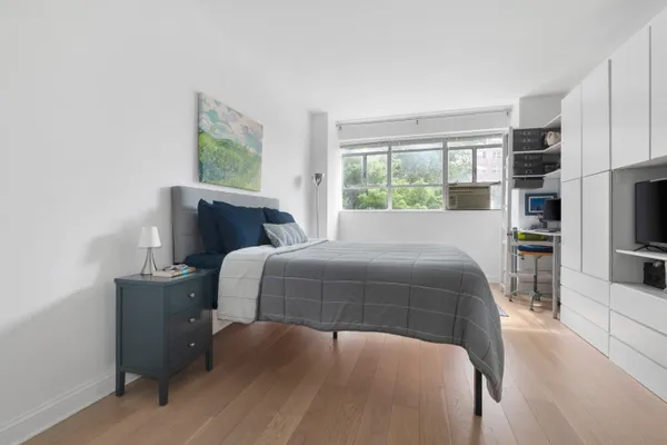 a bedroom with a bed and large window