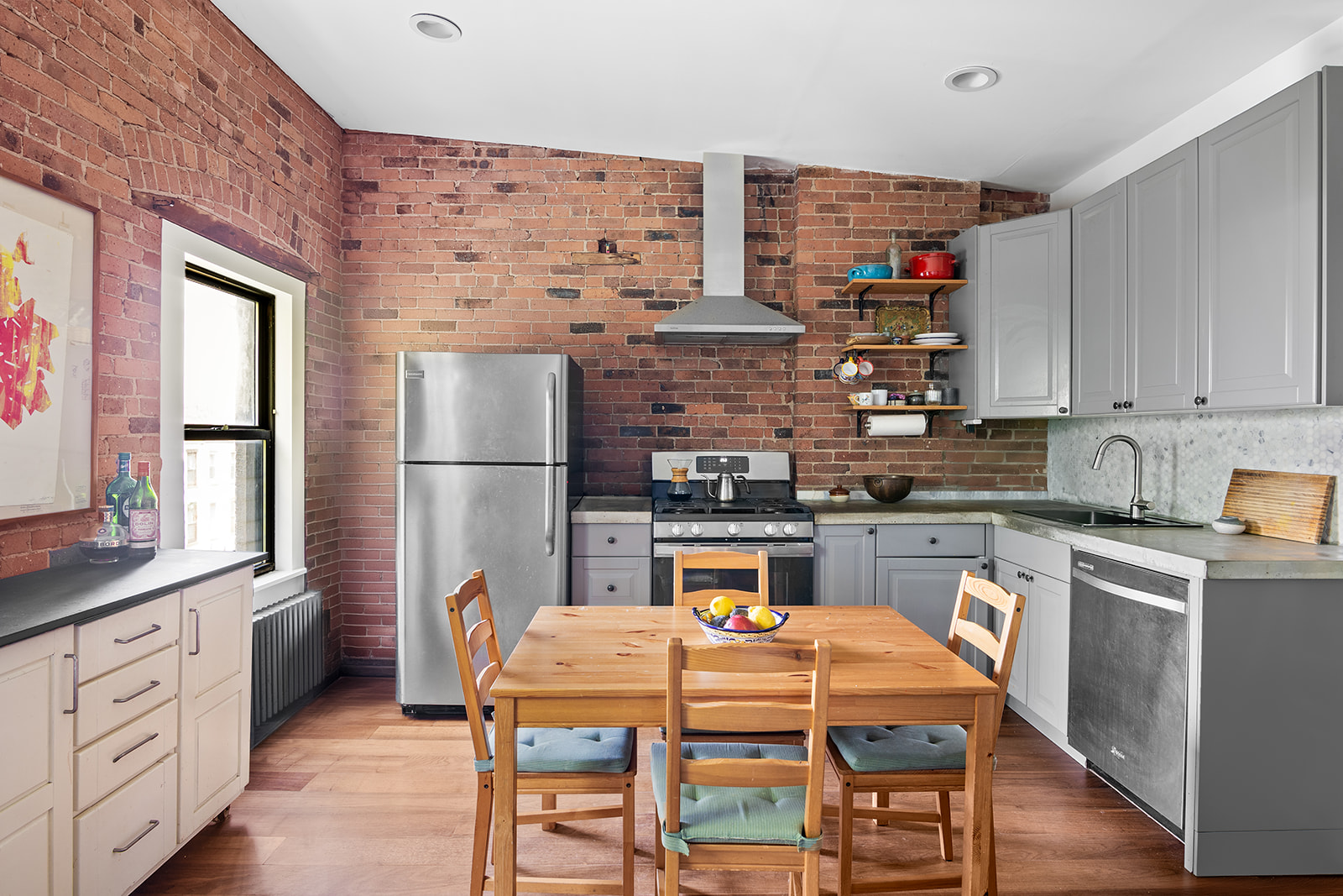 237 Hancock Street, Unit 13 Brooklyn, NY 11216 - Photo 1 of 7 a kitchen with stainless steel appliances a white refrigerator a sink dishwasher a dining table and chairs with wooden floor