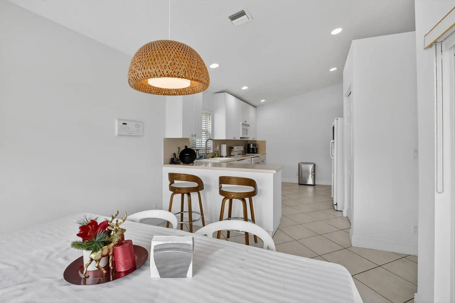 a kitchen with stainless steel appliances a dining table chairs and stove