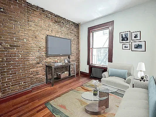 1392 Madison Avenue, Unit 14 Manhattan, NY 10128 - Photo 4 of 4 a living room with furniture and a flat screen tv