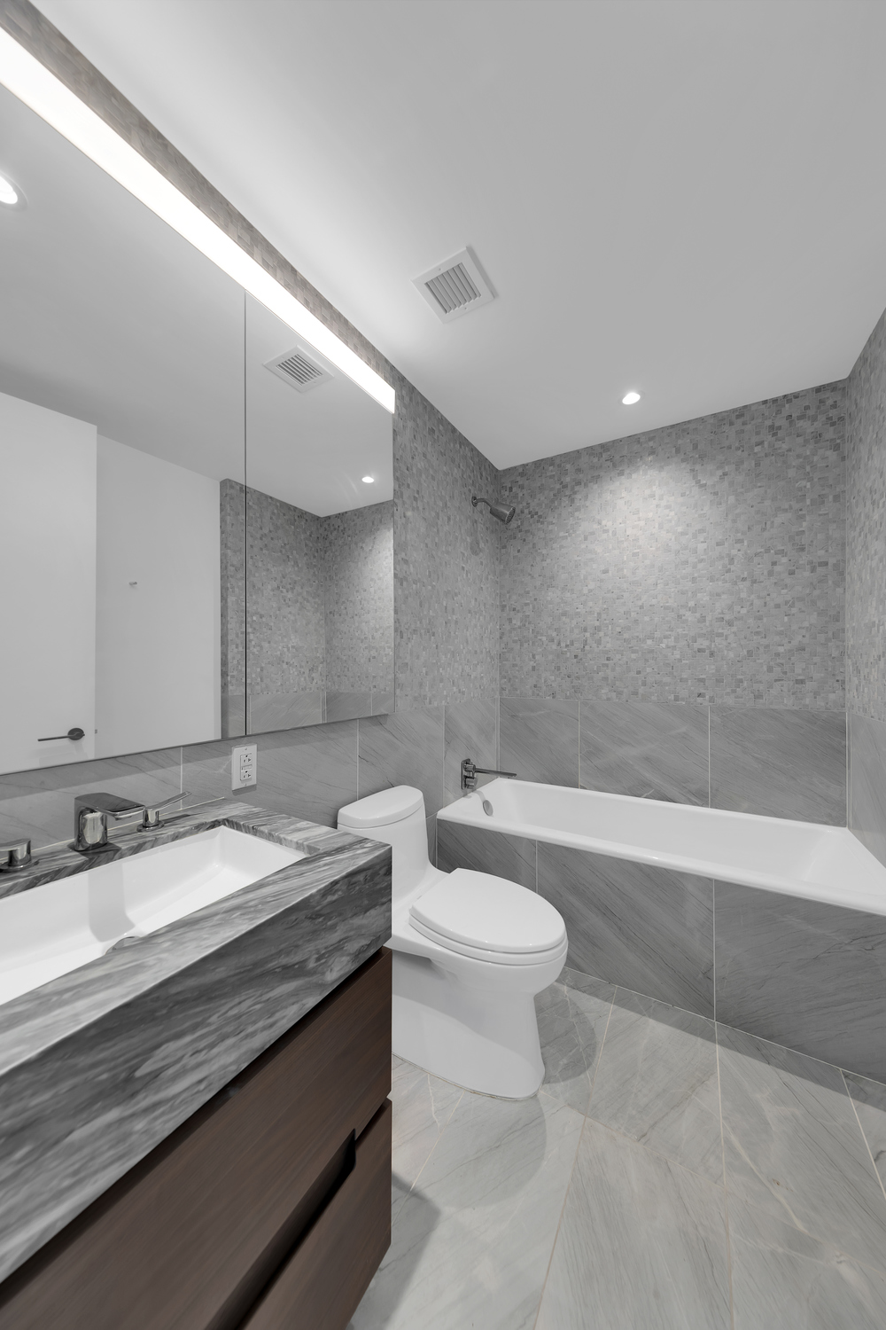 30 Riverside Boulevard, Unit 22A Manhattan, NY 10069 - Photo 9 of 29 a bathroom with a granite countertop sink a toilet a mirror and bathtub