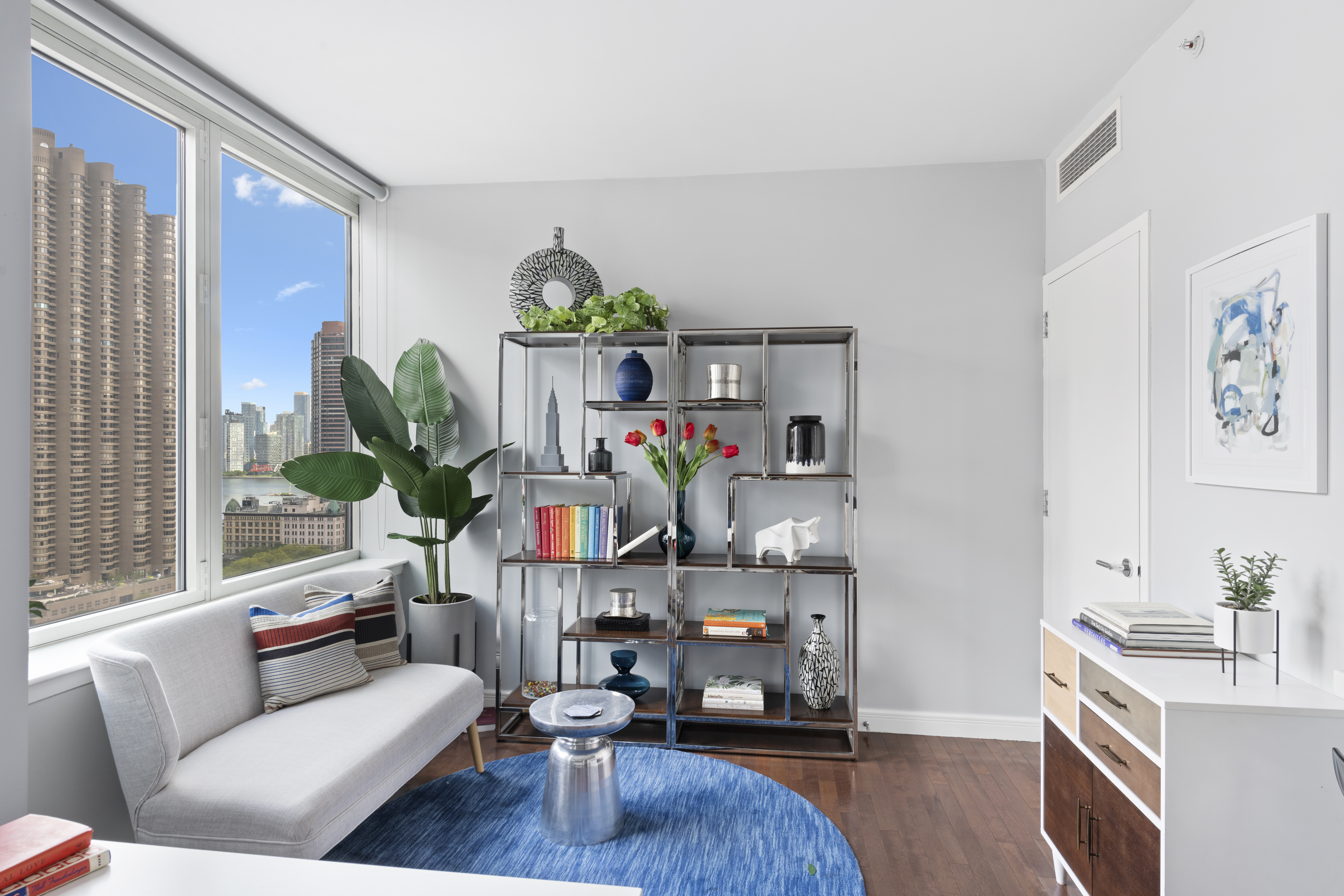 225 East 34th Street, Unit 21I Manhattan, NY 10016 - Photo 5 of 24 a living room with furniture and a book shelf