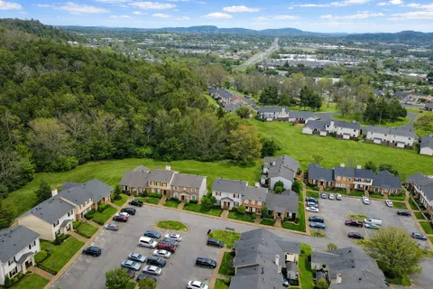 an aerial view of a city with lots of residential buildings ocean and mountain view in back