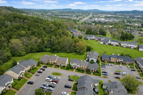 an aerial view of a city with lots of residential buildings ocean and mountain view in back