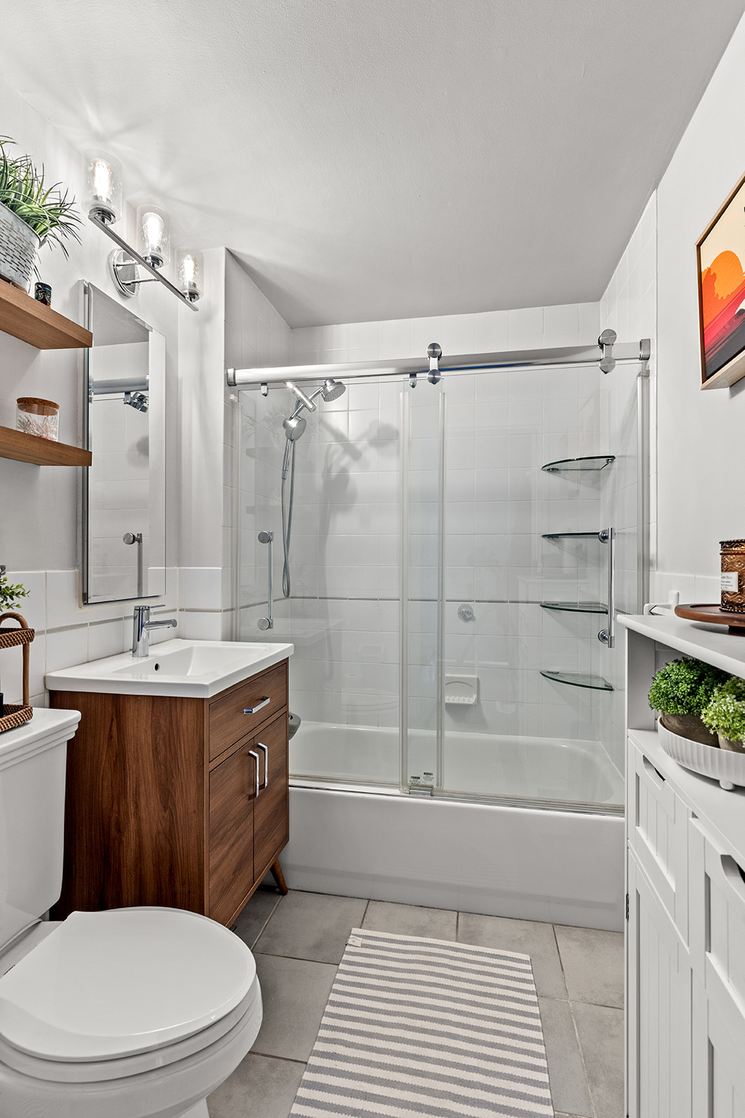 4102 Queens Boulevard, Unit 3D Queens, NY 11104 - Photo 5 of 7 a bathroom with a sink a toilet a mirror and shower