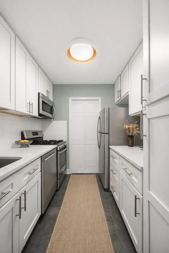a kitchen with white cabinets and white appliances