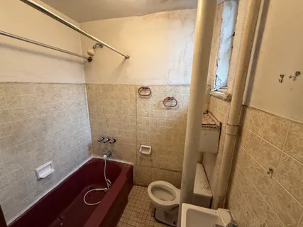 a bathroom with a tub a sink and glass door
